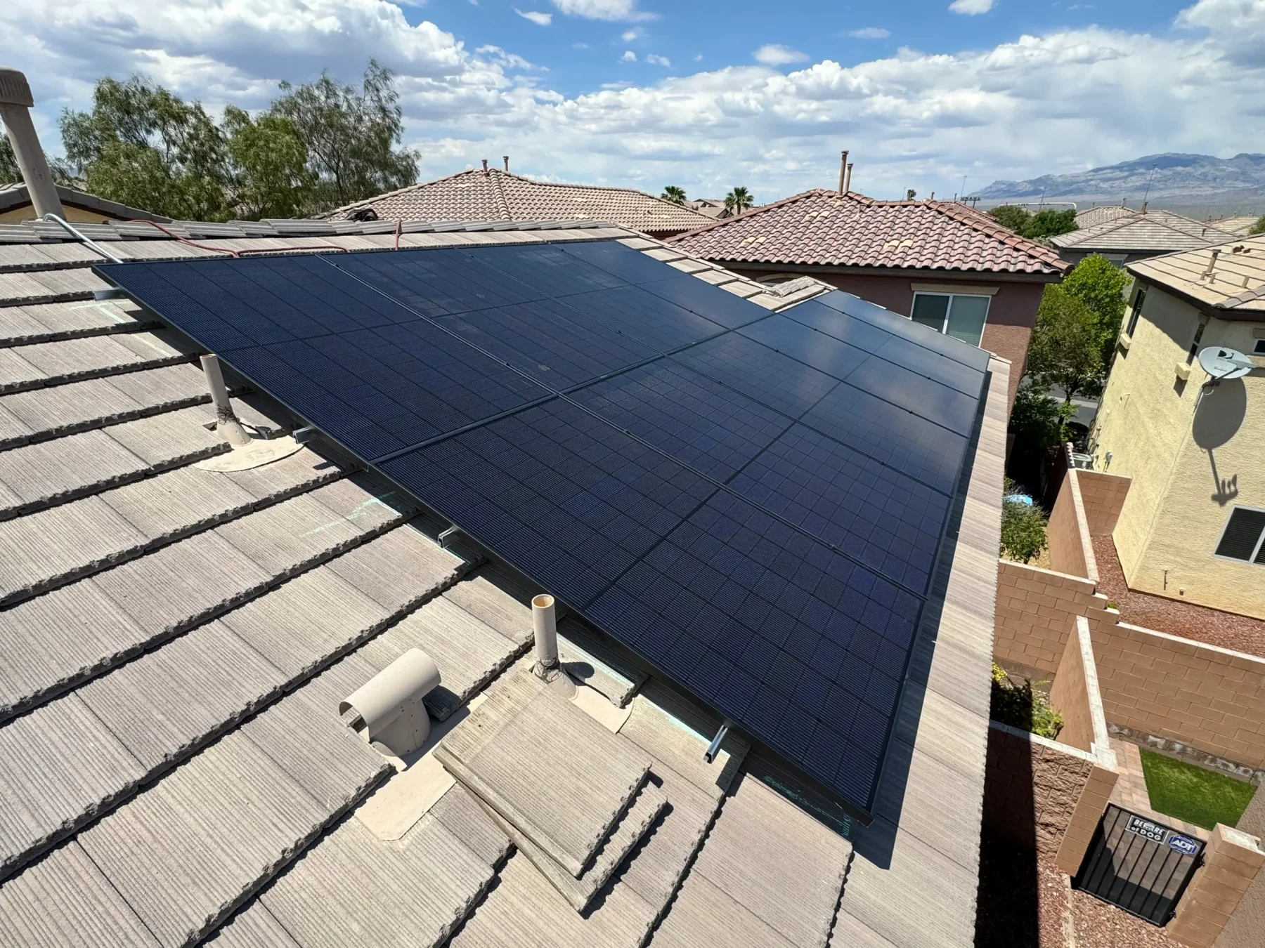 Rooftop solar array with black panels, mounted on Ironridge rails supported by the IntegraRack IR-T1