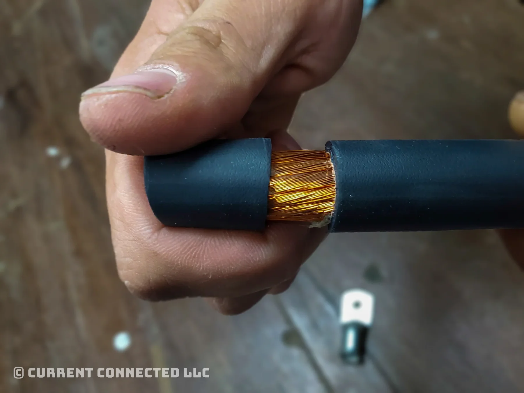 Photo of someone pulling the insulation off a wire. 
