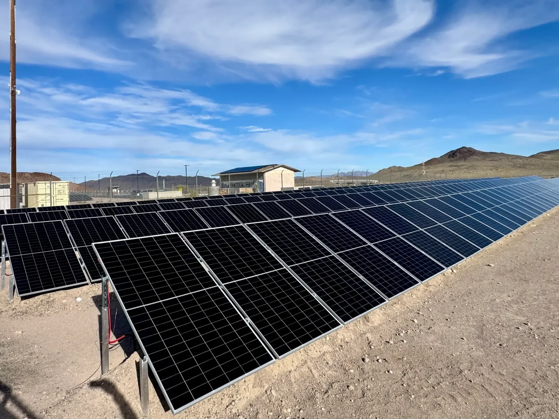 IntegraRack IR-40FSAA solar panel racking used for multiple arrays of solar panels. Blue sky above and gravel below.